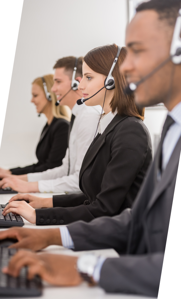 People wearing headsets at computers in an office setting.