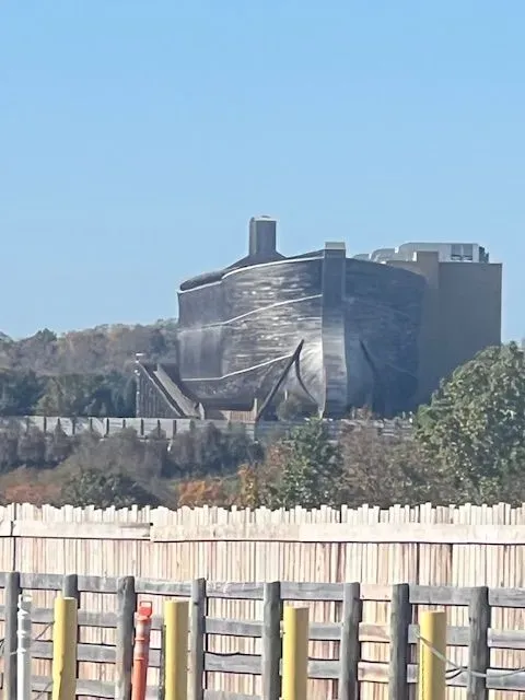 A large building is behind a wooden fence