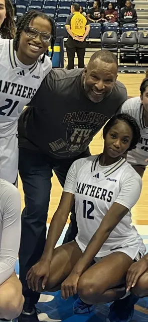 A group of people are posing for a picture on a basketball court.