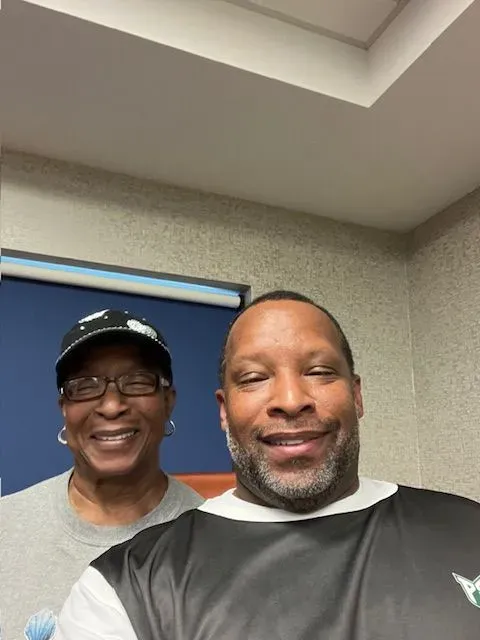 A man and a woman are posing for a picture in a room