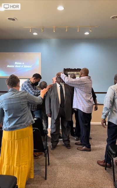 A group of people are standing around a podium in a room.