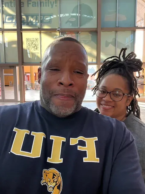 A man and a woman are posing for a picture and the man is wearing a shirt that says uiu