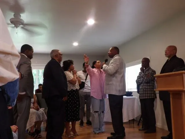 A group of people are standing around a podium in a room.
