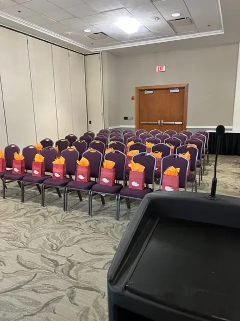 A conference room with rows of chairs and a podium