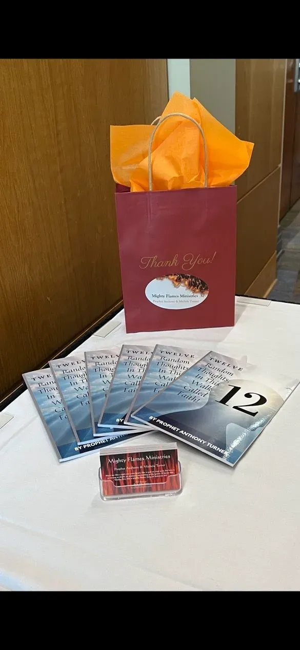 A table with a bag of tissue paper and a bunch of books on it.