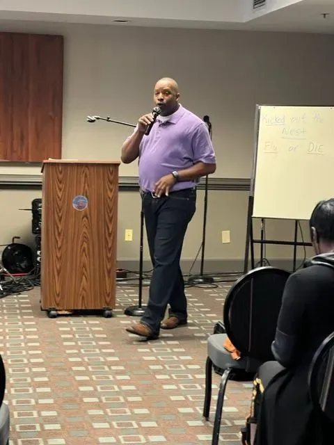 A man is standing at a podium talking into a microphone.