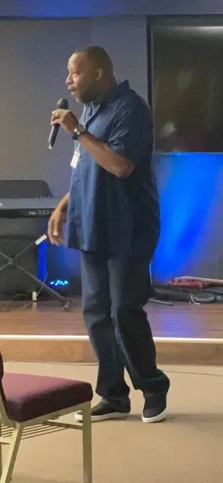 A man is standing on a stage holding a microphone.