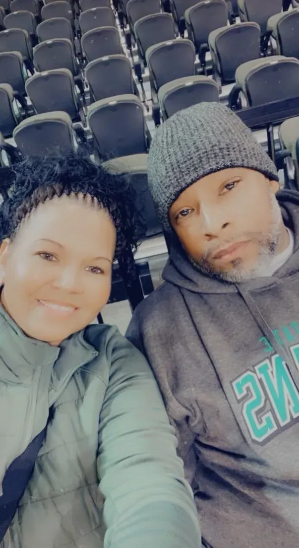 A man and a woman are taking a selfie in a stadium.
