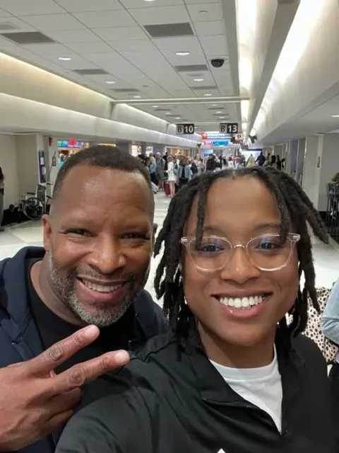 A man and a woman are posing for a picture at an airport