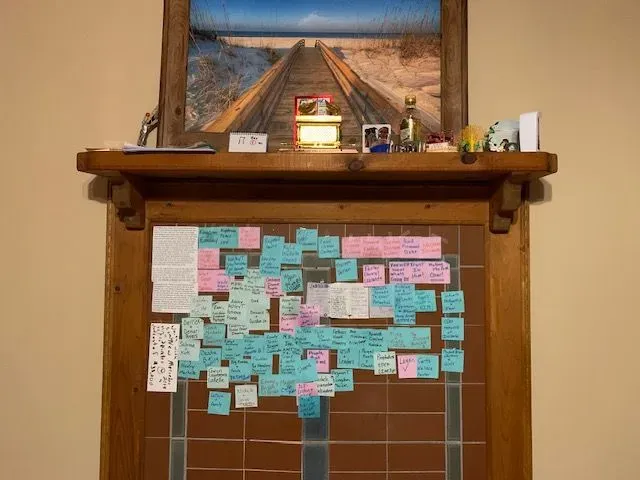 A mantle with a lot of sticky notes on it