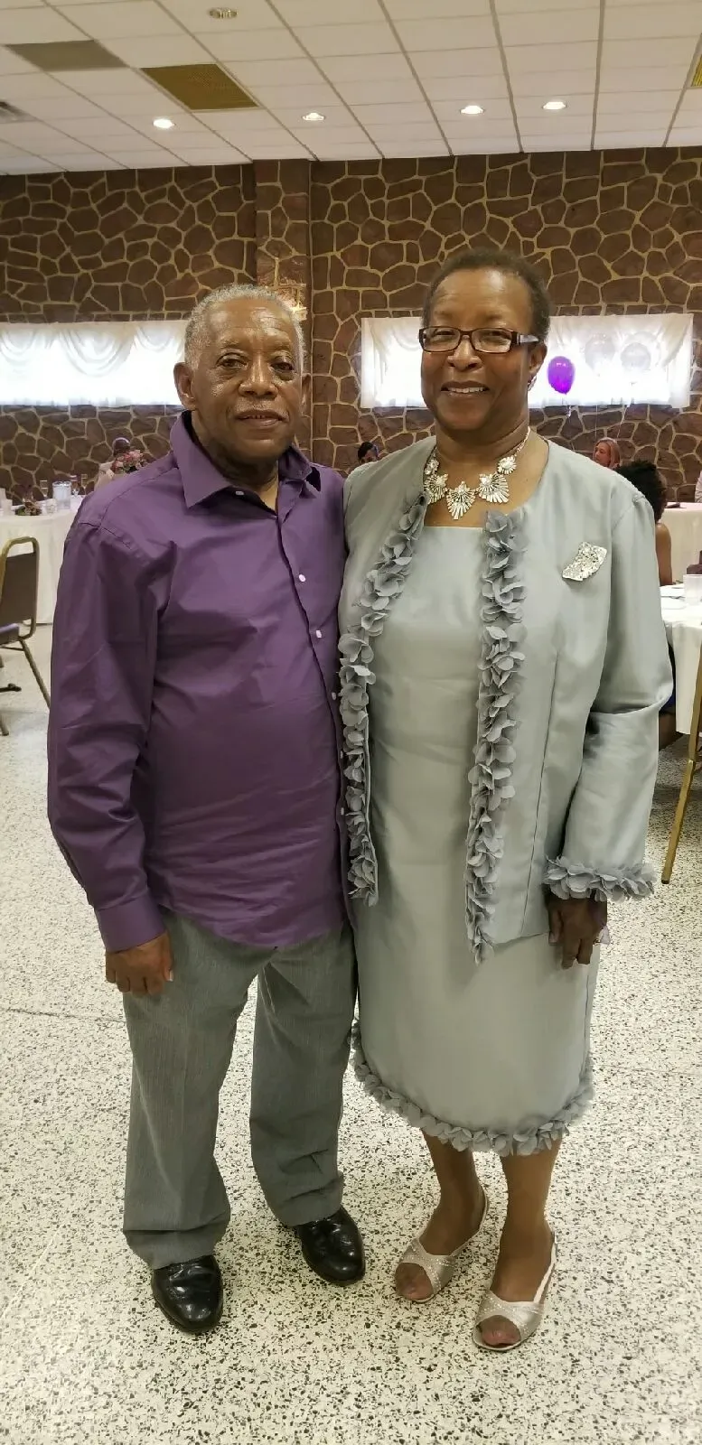 A man and a woman are posing for a picture in a room.