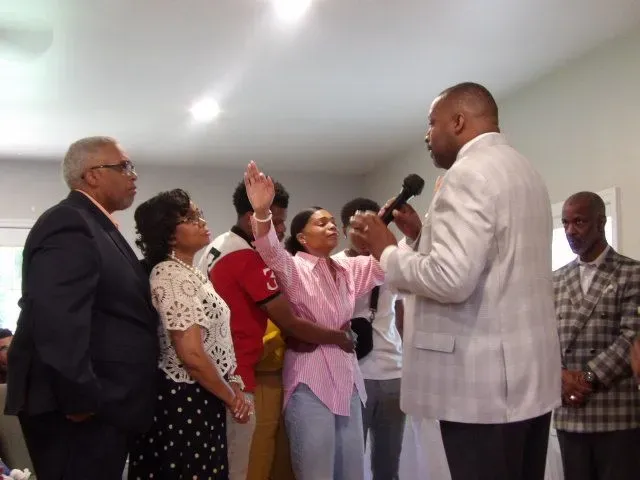 A group of people standing around a man holding a microphone