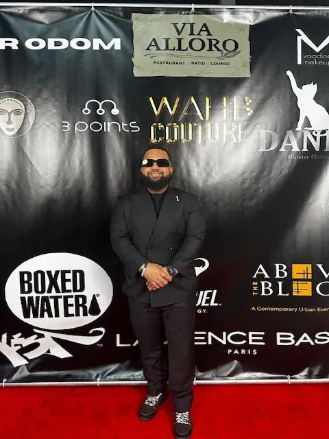 A man standing in front of a sign that says boxed water
