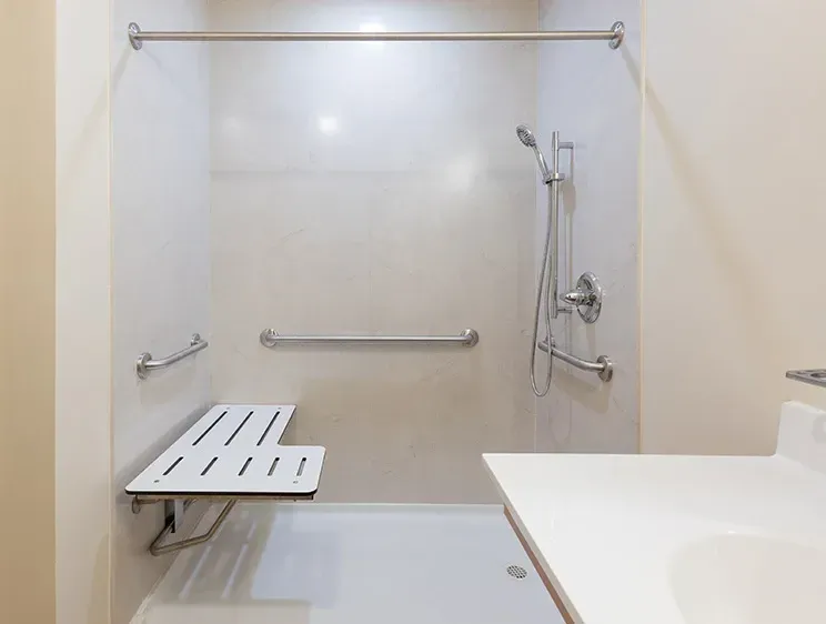A bathroom with a walk in shower and a sink.