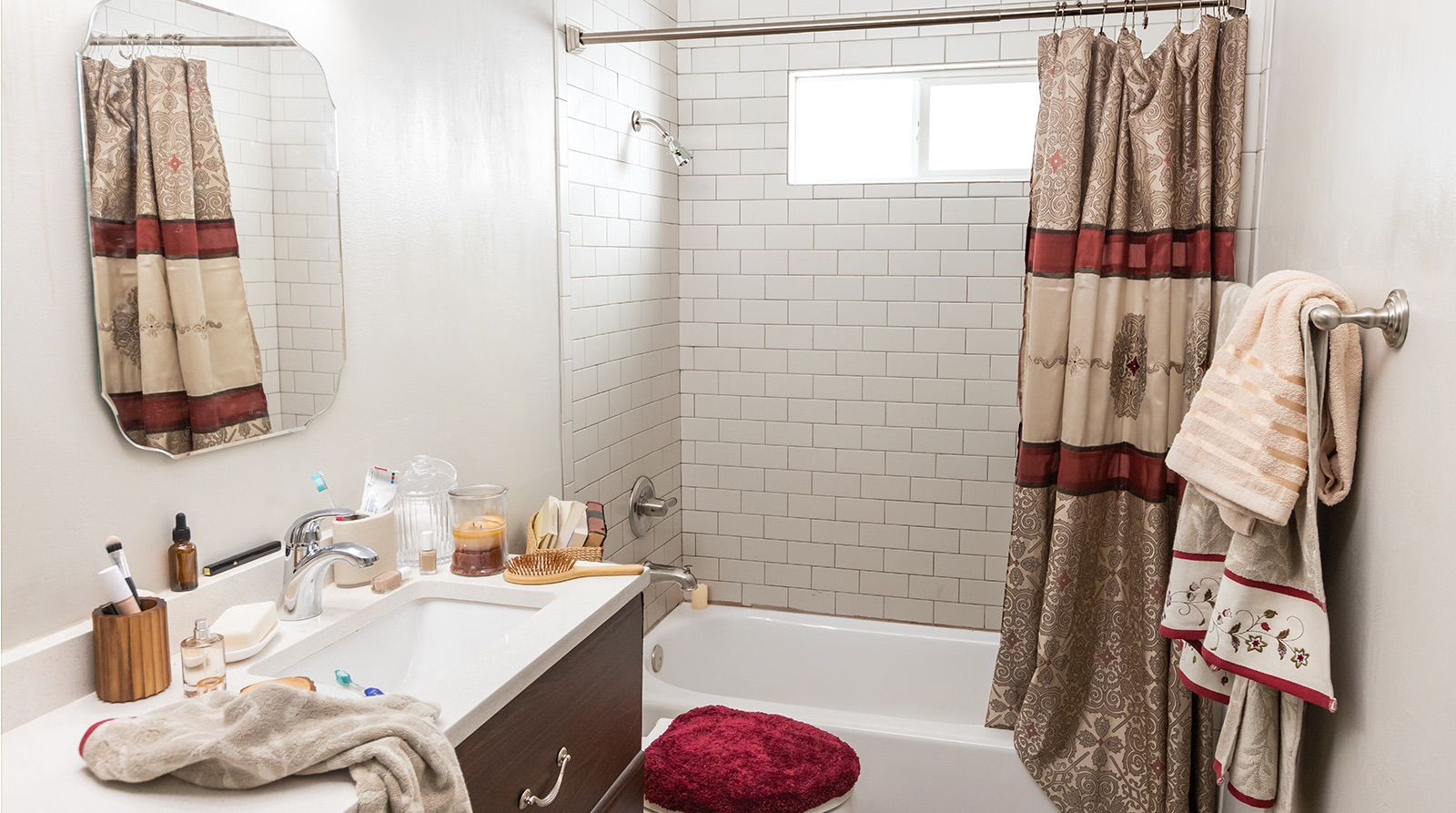 A bathroom with a tub , sink , mirror and shower curtain.