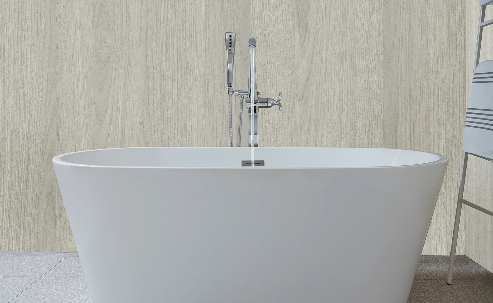 A white bathtub is sitting in a bathroom next to a towel rack.