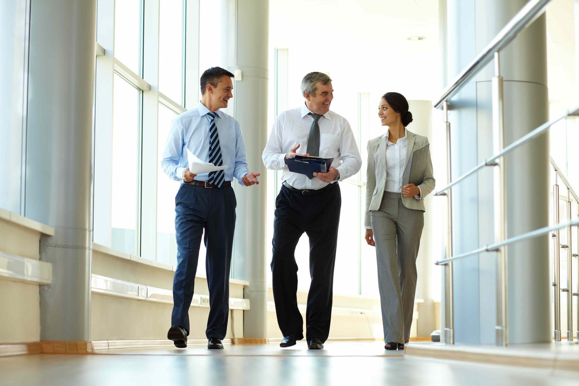 a group of business people are walking down a hallway