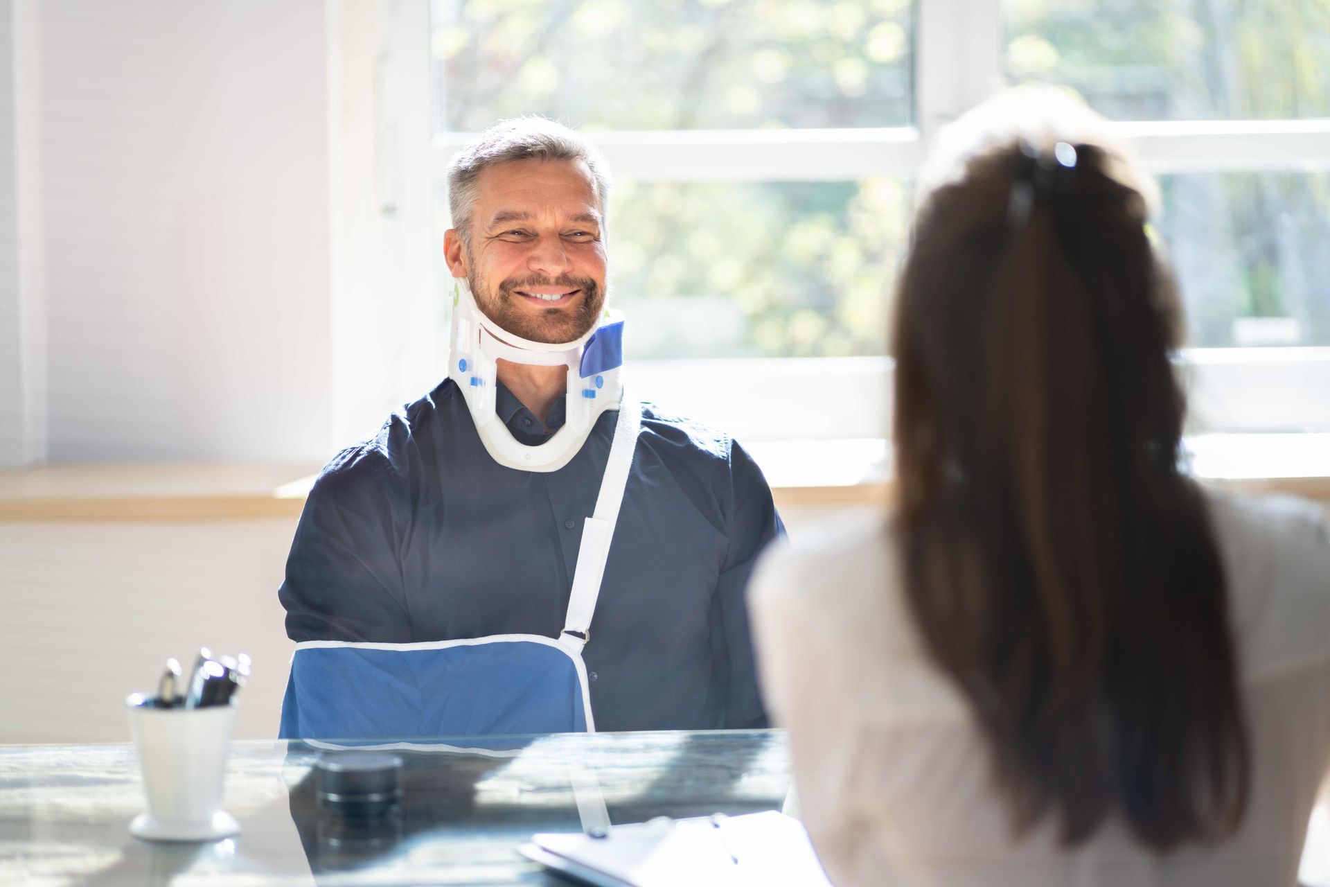 a man with a broken neck is sitting at a table with a woman