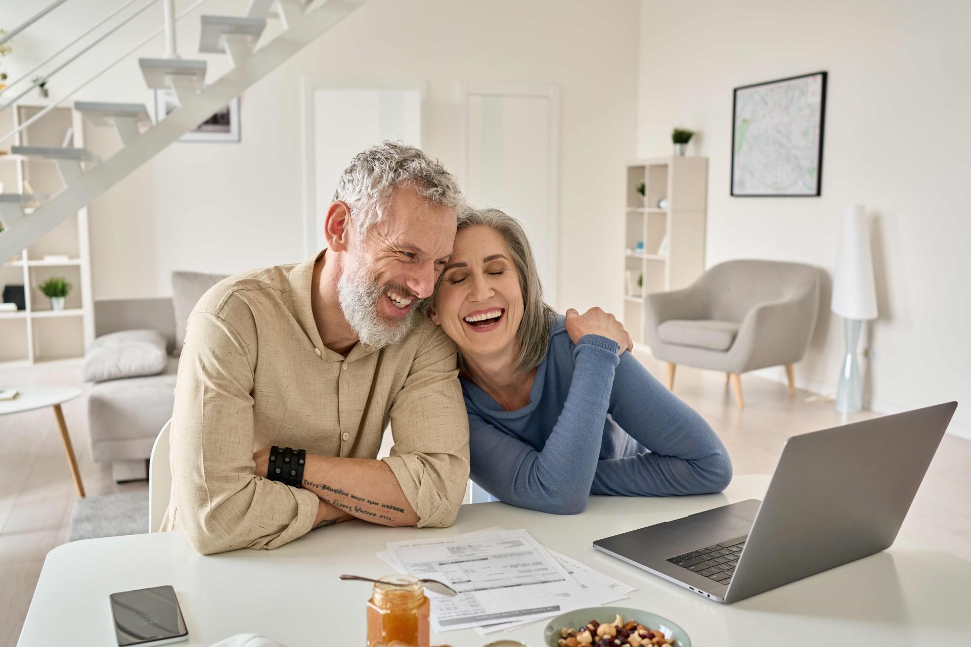 a man and a woman are sitting at a table with a laptop