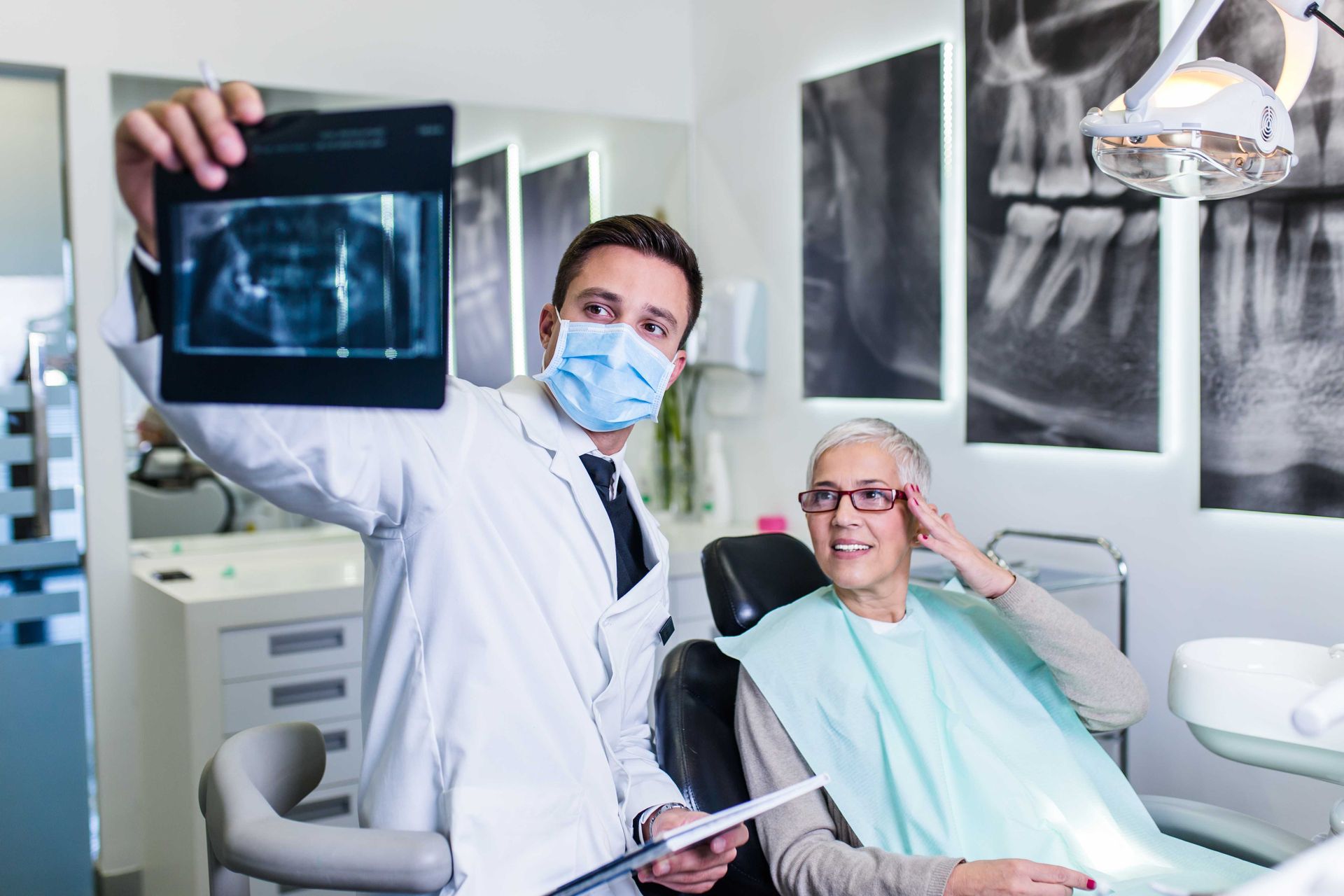 a dentist is looking at an x-ray of a patient 's teeth