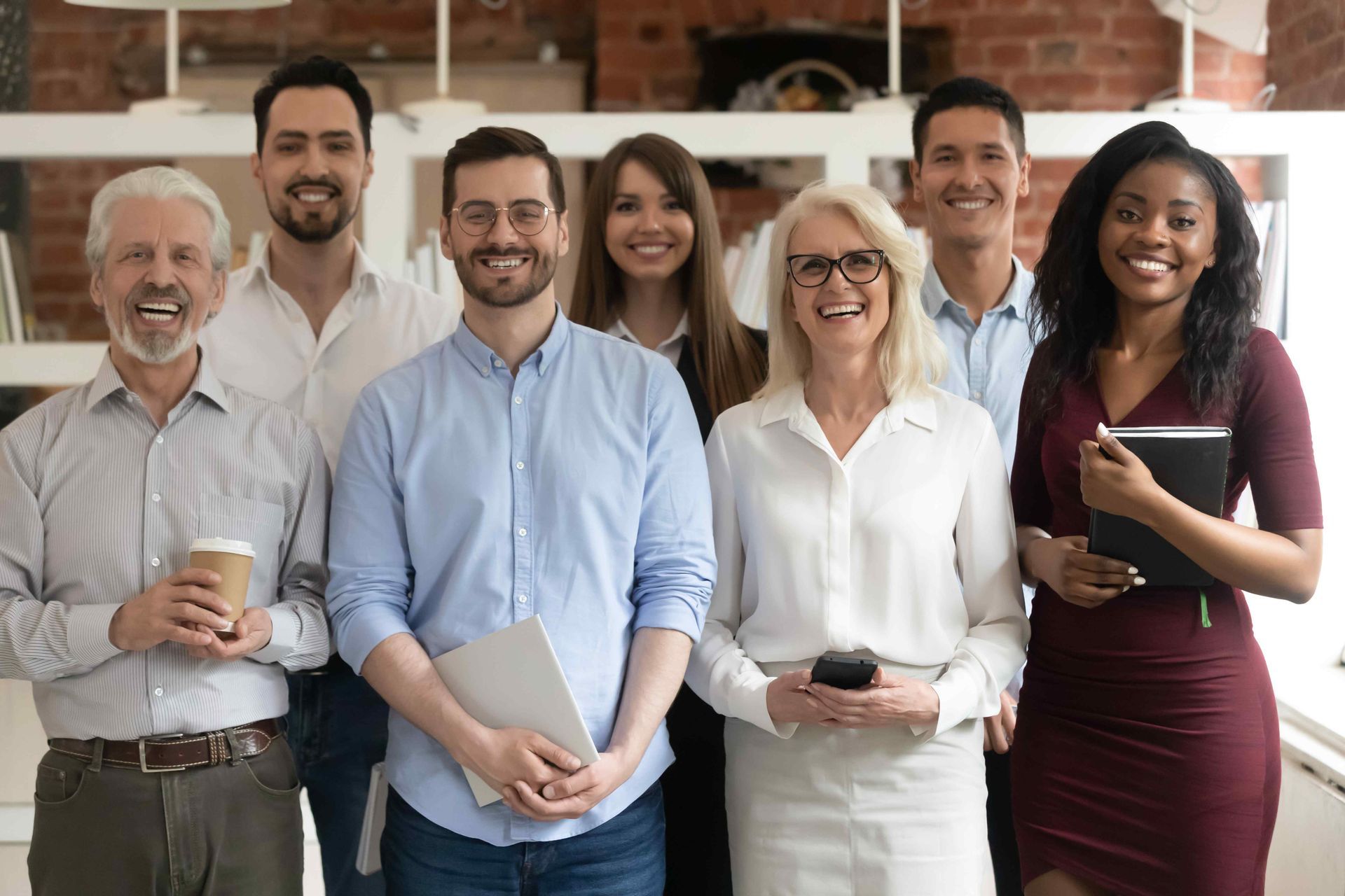 a group of people are posing for a picture together in an office