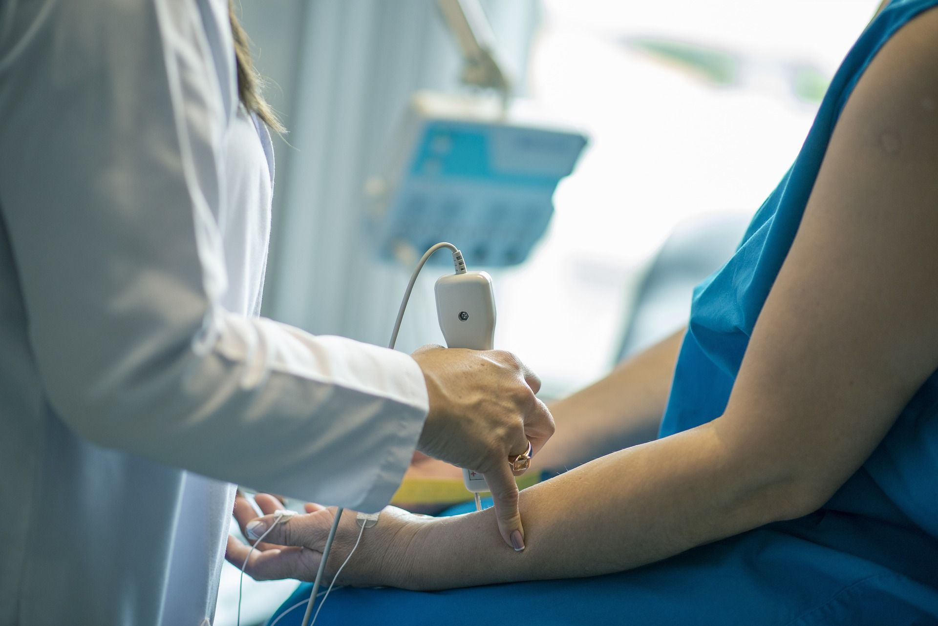 a doctor is examining a patient 's arm with a device 