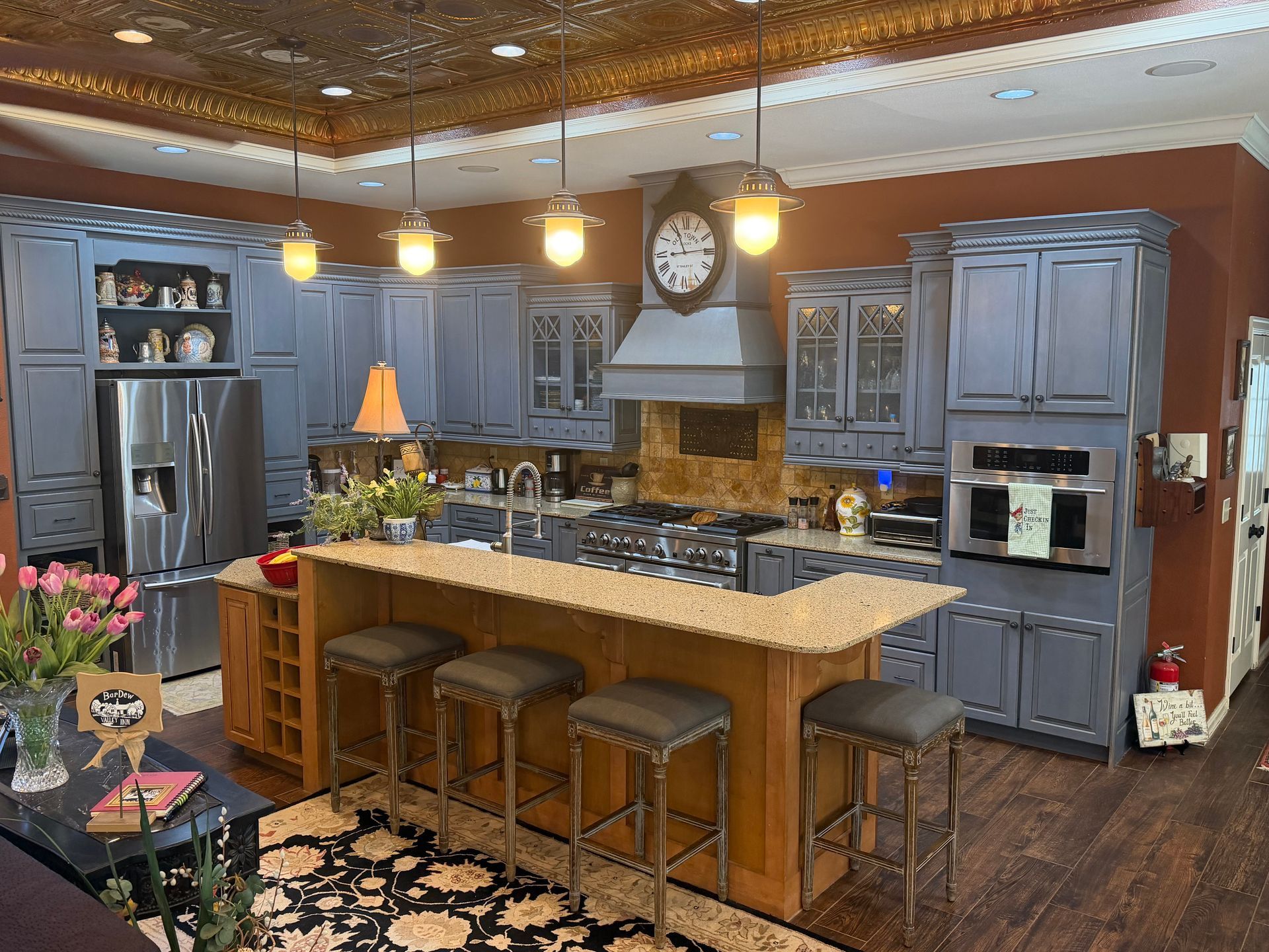 Modern kitchen with gray cabinets, large island, pendant lights, and hardwood floors