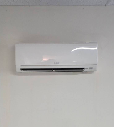 White wall-mounted air conditioner on a plain light wall