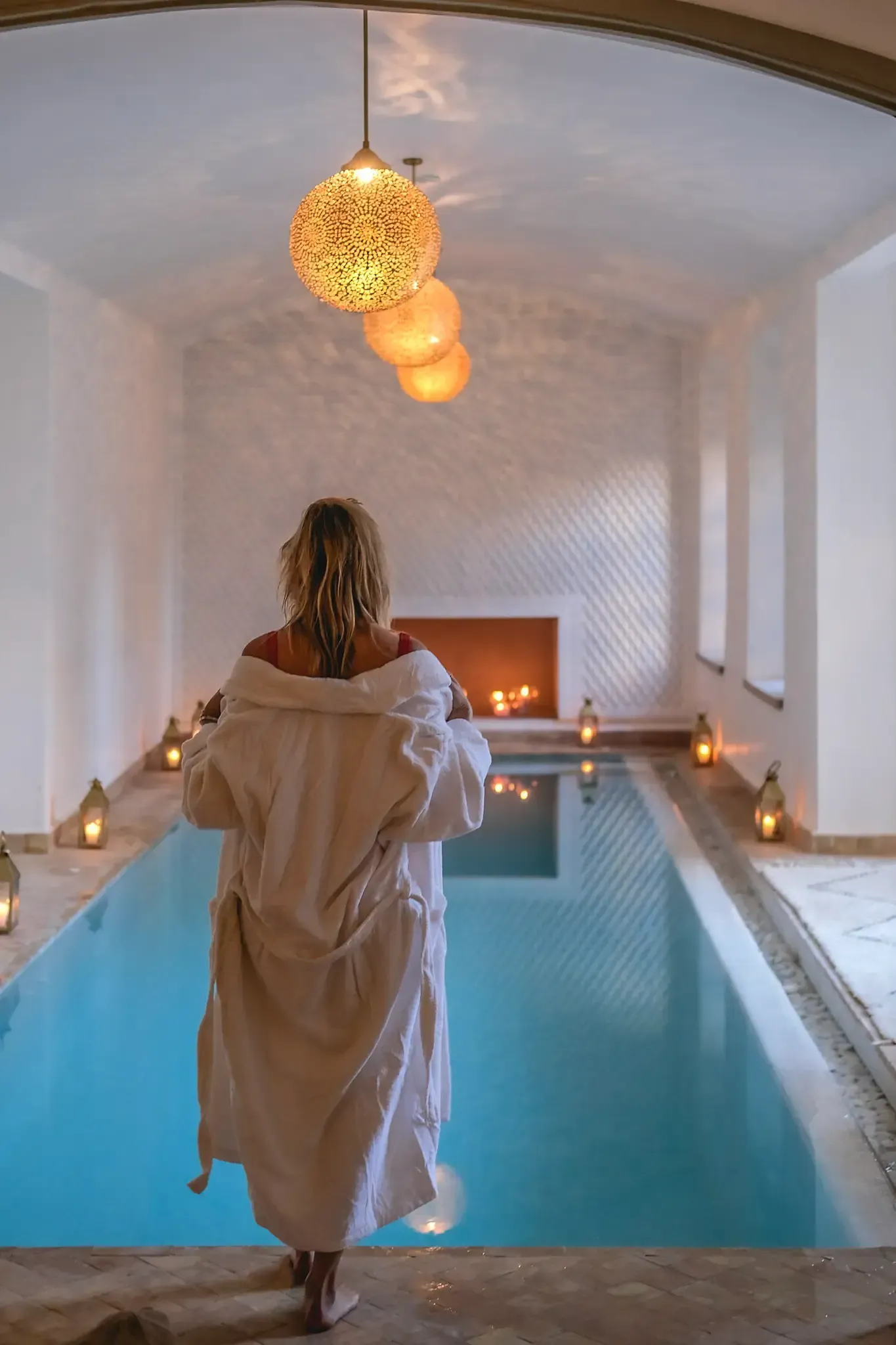 Femme qui rentre dans la piscine intérieure chauffée de Les Bains de Marrakech dans une ambiance apaisante