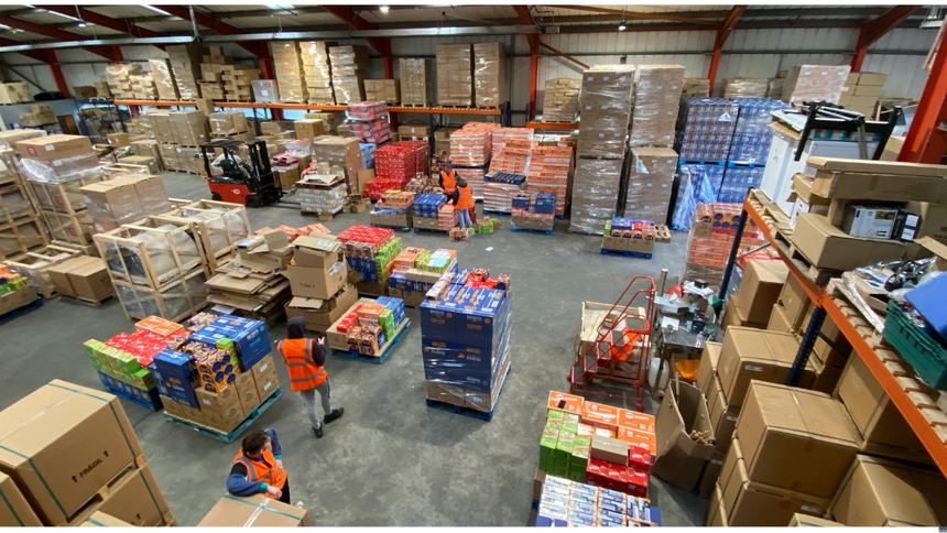 A large warehouse filled with lots of boxes and people
