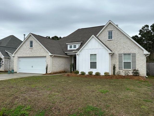A picture of a white and tan house with white gutters in Covington, LA