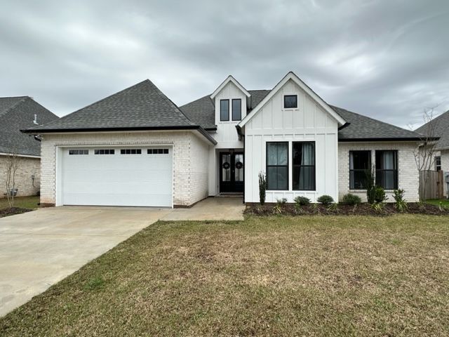 A picture of a white house with a garage and seamless gutters in covington, LA