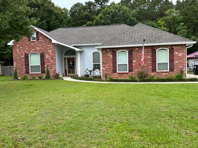 A picture of a red brick home with white gutters in Covington, LA