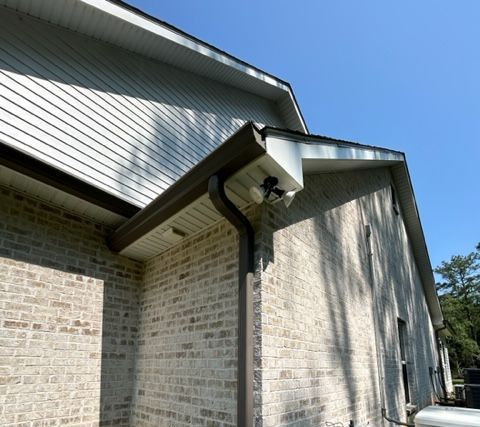 A picture of the side of a brick house showing the brown seamless gutters in Covington, LA