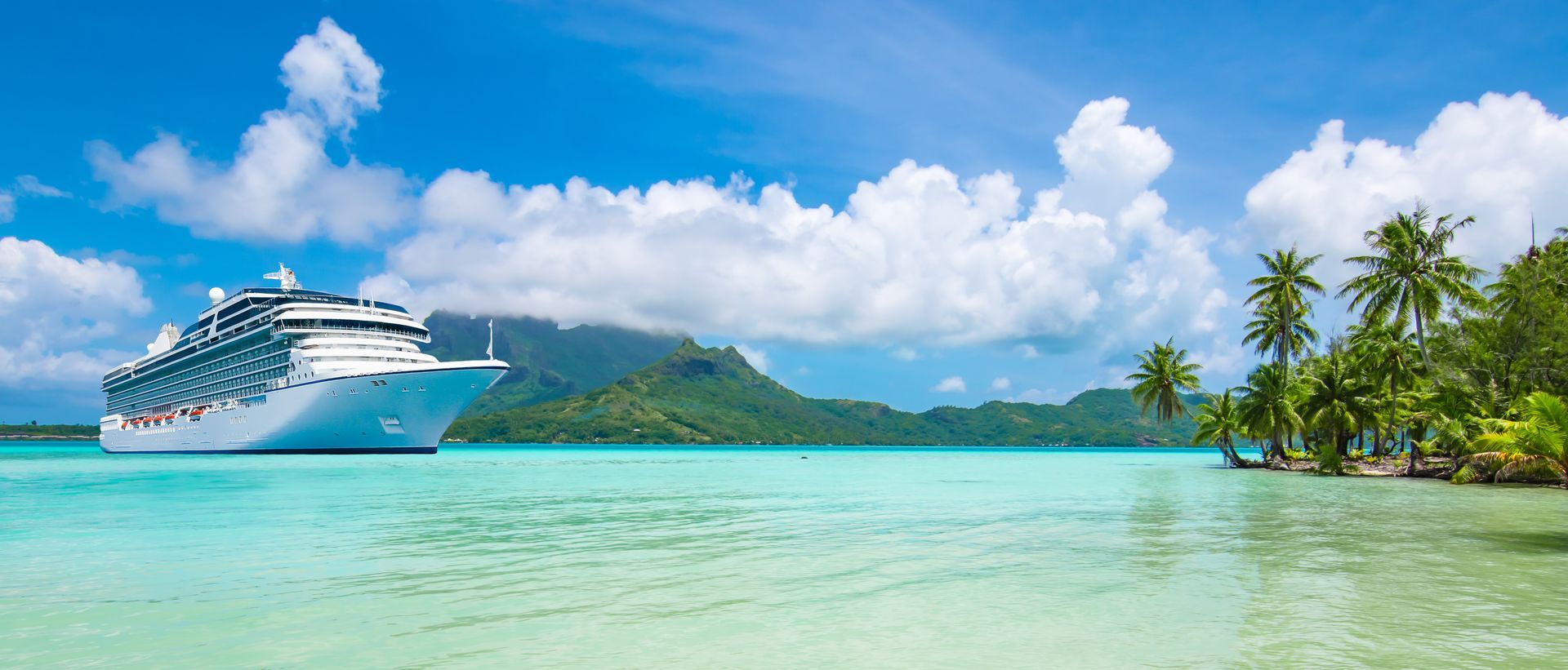 A cruise ship is floating on top of a tropical island in the ocean.