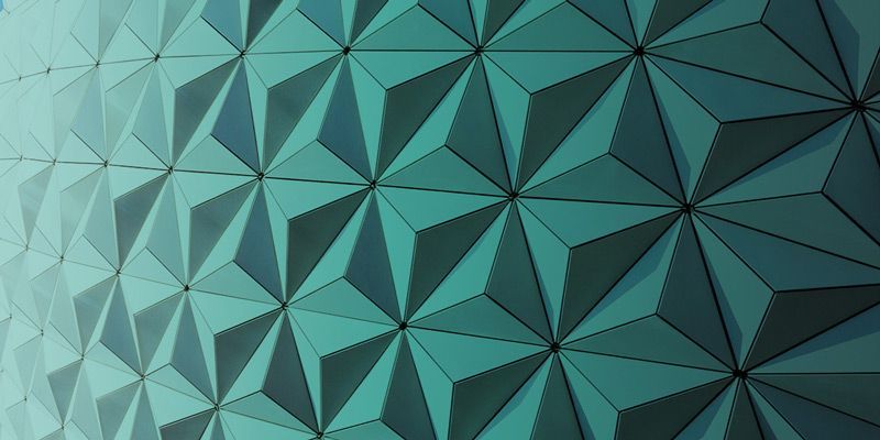 Petrolfarbene geometrische Wand mit sich wiederholenden wabenförmigen Mustern.