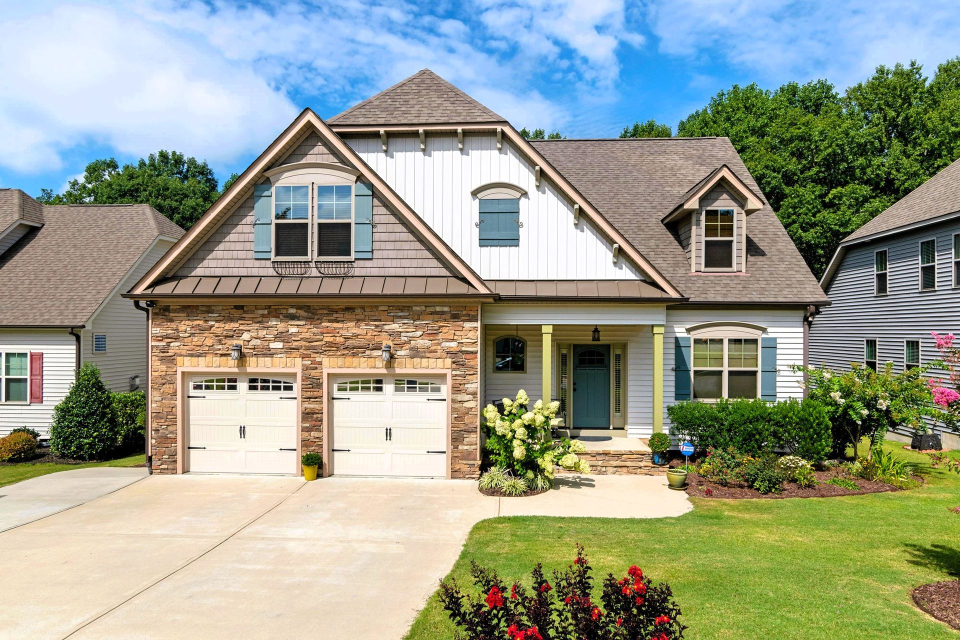 Suburban house with stone accents and a concrete driveway with a double garage
