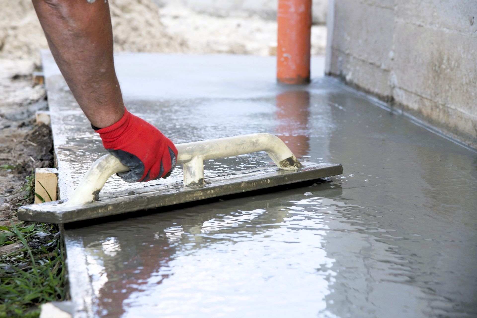 Worker smoothing concrete on a DIY home concrete project
