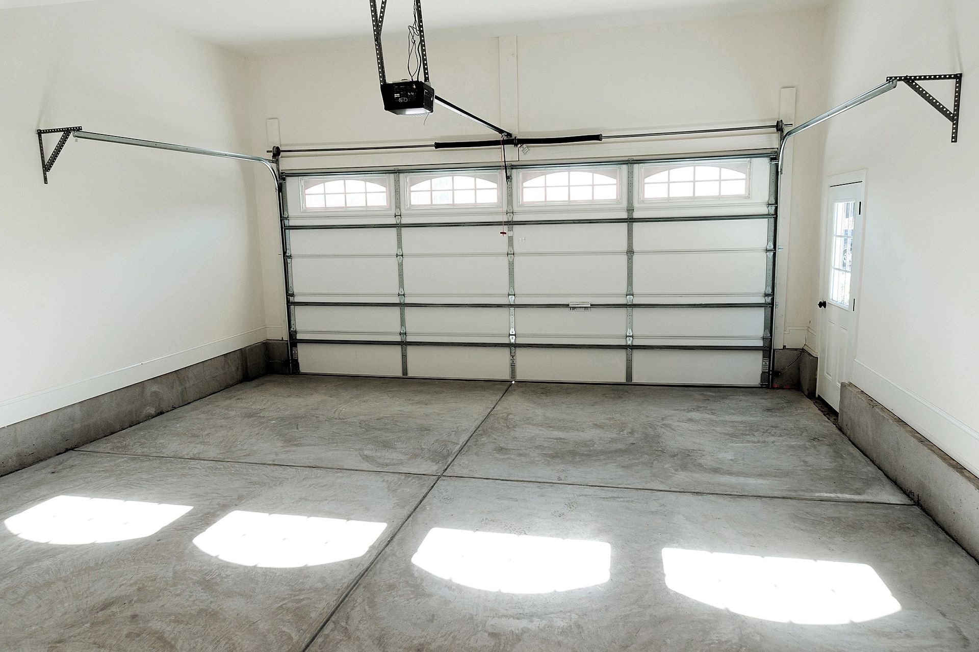 clean garage with a smooth concrete floor and white door