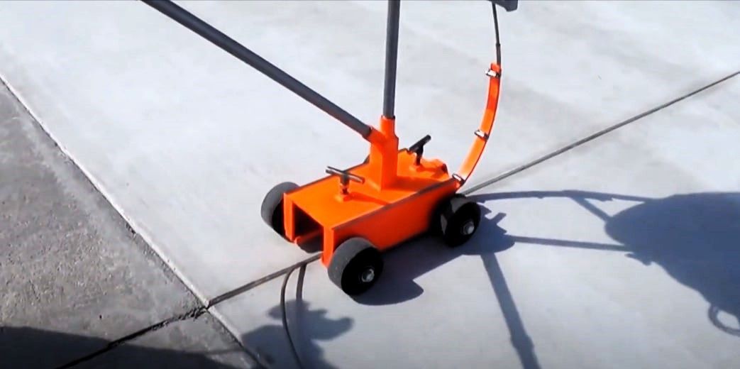 Backer rod installer in action on concrete surface