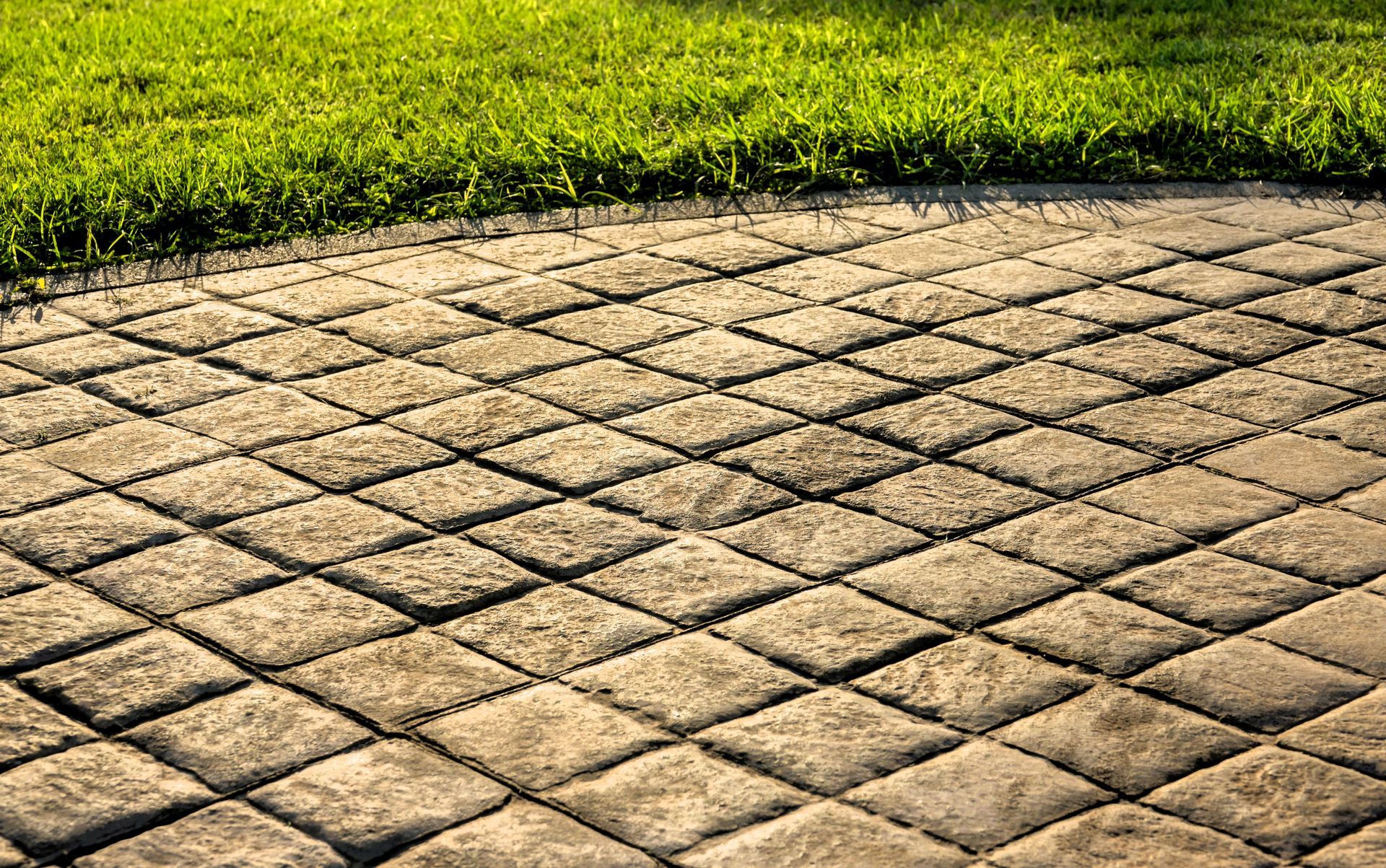 Stamped concrete driveway featuring an outdoor tiled pattern