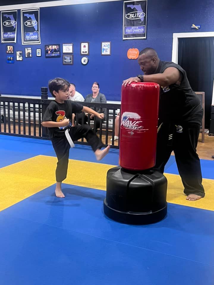 A group of people are practicing martial arts in a gym.