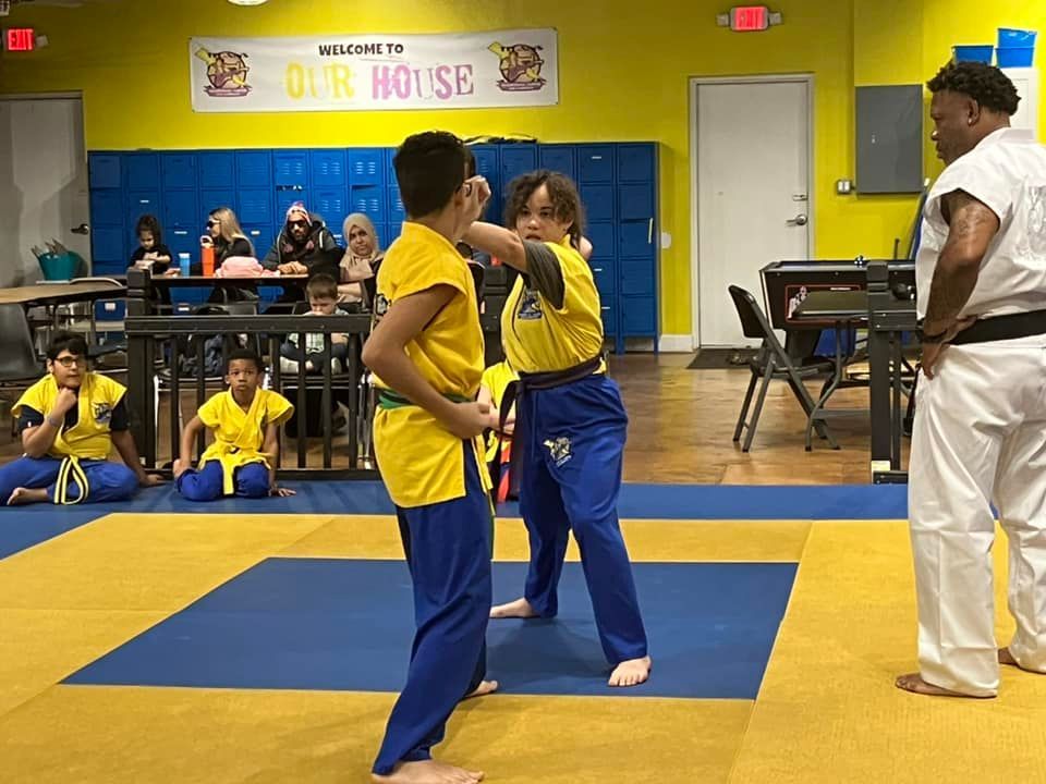A group of people are practicing martial arts in a gym.
