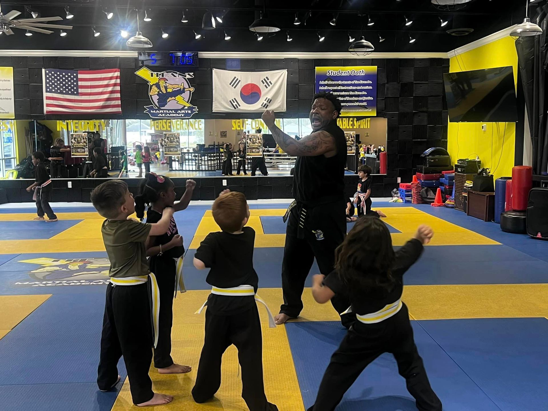 A group of children are practicing martial arts in a gym