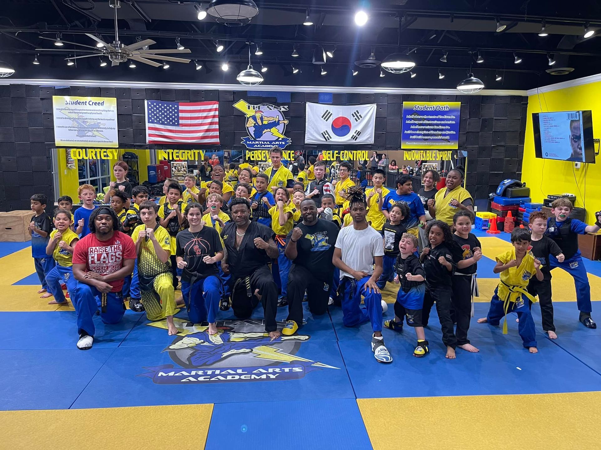 A group of people are posing for a picture in a gym.