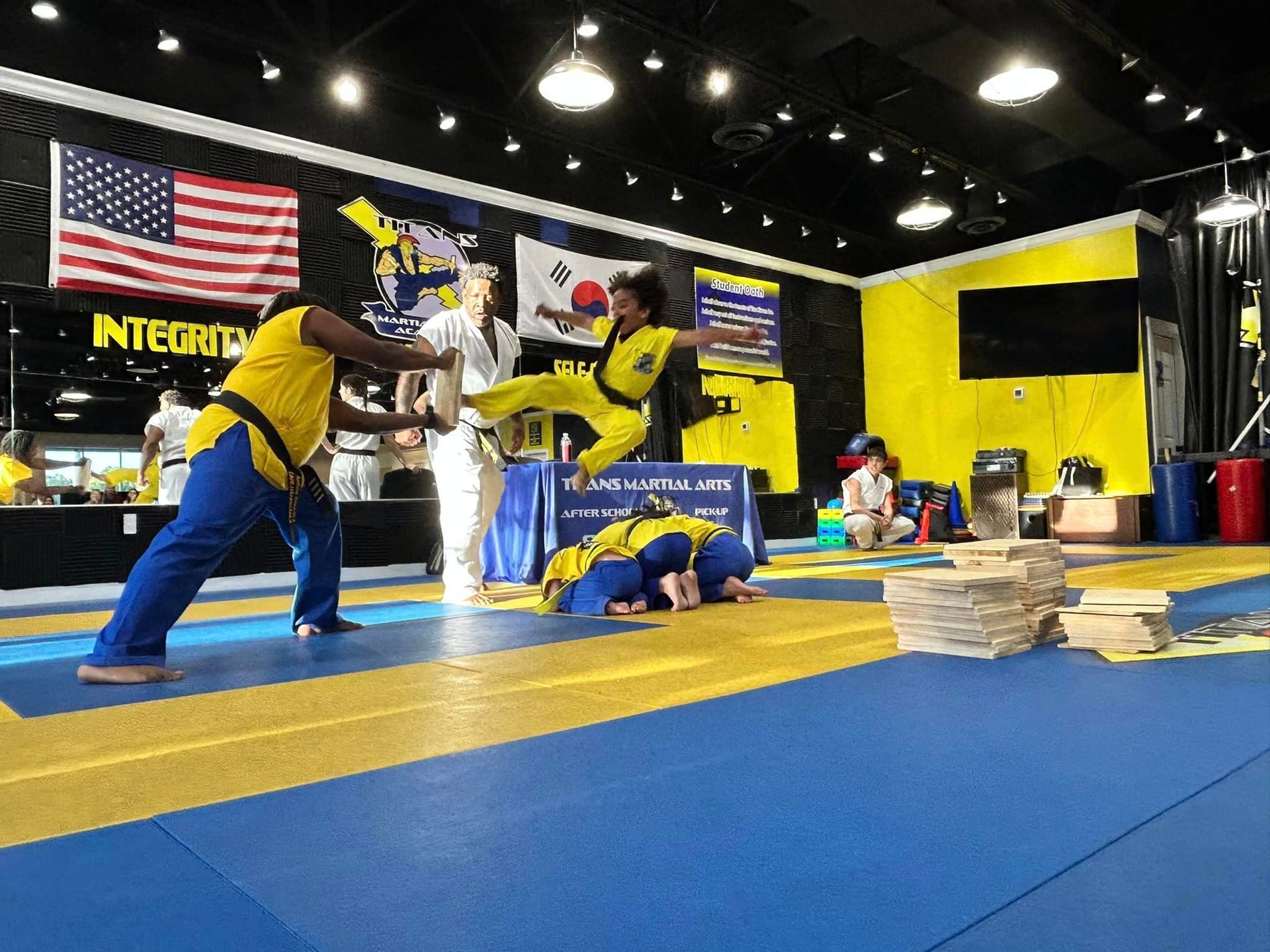 A group of people are practicing martial arts in a gym.