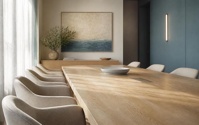 Modern conference room with a long wooden table, beige chairs, and a blue accent wall with abstract artwork.