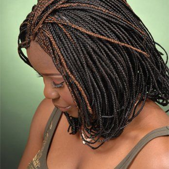 A woman with braided hair is wearing a green tank top