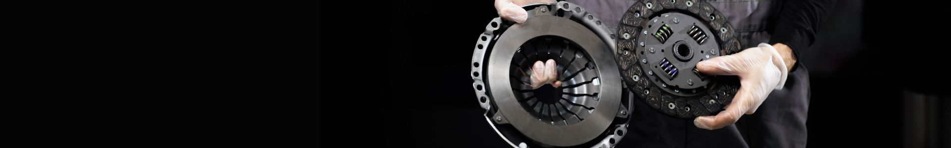 A mechanic's gloved hand works on a clutch replacement.