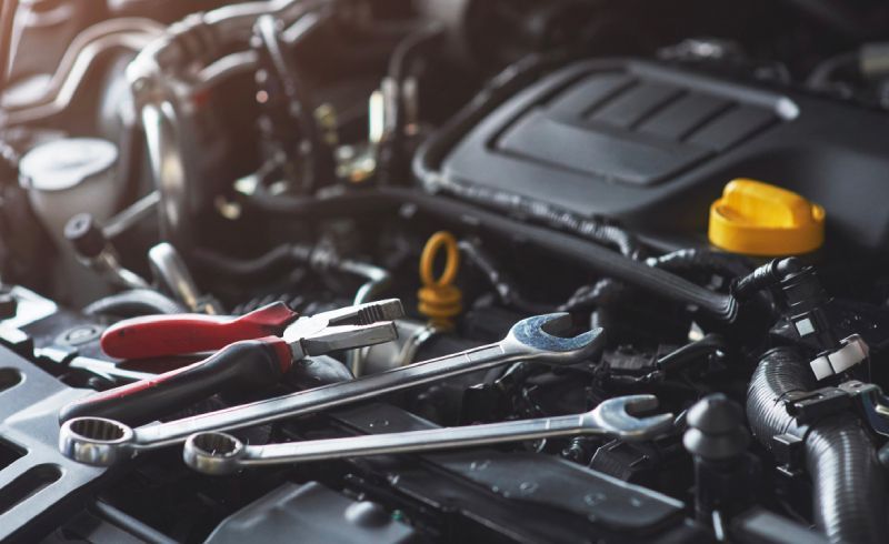 Technician tools resting on a vehicle engine during import and domestic auto repair service in Santa Cruz